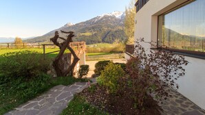 A stone pathway leading to a building with a mountain view. - Chalets St. Wendelin (Telfs)