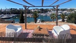 A terrace with a view of a marina, white chairs, a table, and a pergola. - House for 8 people (4 bedrooms) with swimming pool and superb view of the marina (Cala d'Or)