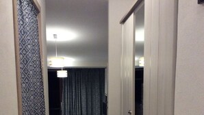 A narrow hallway with a wardrobe, a small kitchen area, and a dark room with curtains. - Palau (OT), 650 meters from the beach, ideal for couples and families (PALAU (OT))