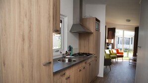 Una cocina moderna con armarios de madera, una estufa a gas y un lavamanos.