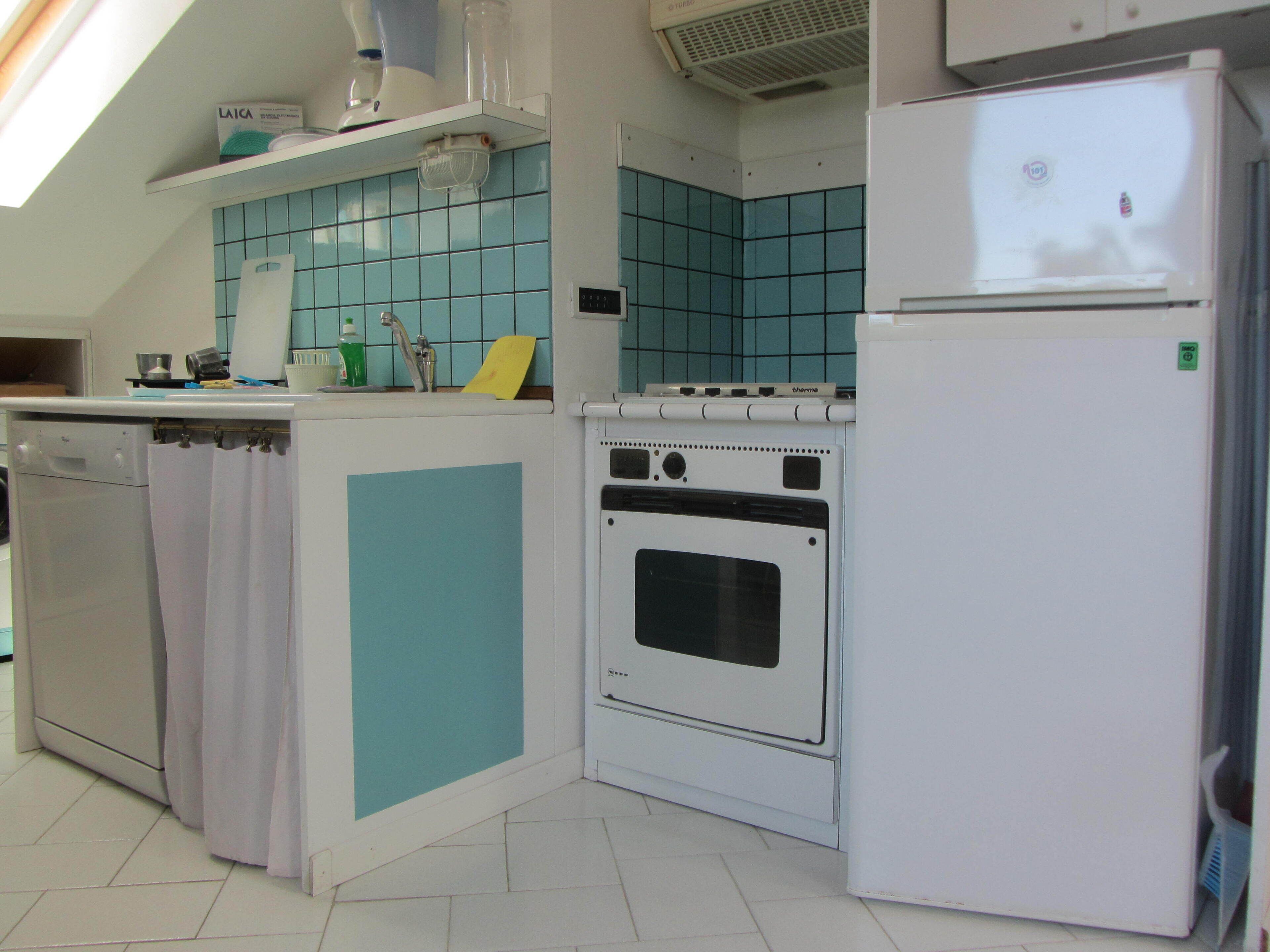 Uma cozinha equipada com máquina de lavar louça, forno e frigorífico.
