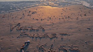 A beach with footprints and the words "Viva La Vida" and "Kiss Kiss" written in the sand. - VILLA SUNSET KISS•SW•DREAMLESS BEAUTIFUL•CHANNEL CROSSING WITH SEA ACCESS ***** (Cape Coral)