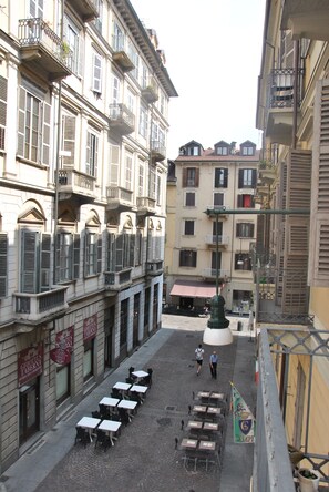A courtyard with outdoor seating and a fountain, surrounded by multi-story buildings with balconies and shutters. - Casa Rattazzi, elegant apartment in the heart of the city (torino)