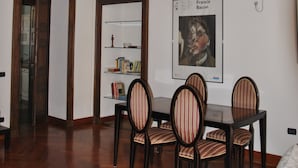 A dining area with a wooden table and chairs, a bookshelf, and a ceiling with intricate designs. - Casa Rattazzi, elegant apartment in the heart of the city (torino)