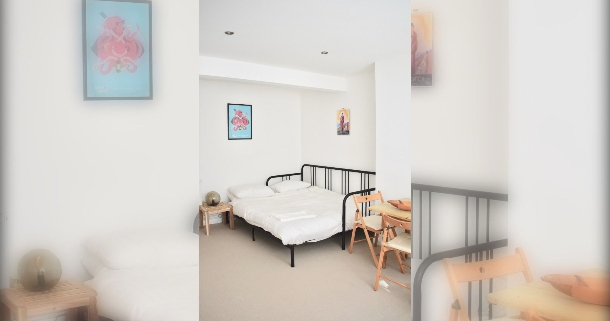 Une chambre à coucher avec un lit, une petite table, une chaise et un mur orné de tableaux.