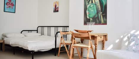 A bedroom with a bed, a desk, a chair, and a poster on the wall.