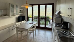 Una cucina moderna con zona pranzo, ampie finestre e vista sull'esterno.