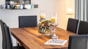 Una mesa de madera para comer con velas y un arreglo floral.