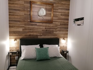 Cozy retreat with a large bed, two bedside tables, and a framed artwork.