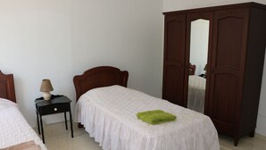 A bedroom with a bed, a nightstand, a lamp, and a wardrobe. - Flic En Flac: Cosy Apartment in a nice setting (Flic en Flac)