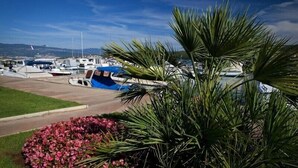 A marina with boats docked, a grassy area, and a palm tree. - 4 star romantic villa, just a minute walk to the beach, heated pool. (Cizici)