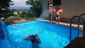 A swimming pool with a wooden deck and metal railings. - 4 star romantic villa, just a minute walk to the beach, heated pool. (Cizici)
