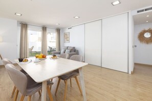 Un salon moderne avec un canapé, une table à manger et des chaises.
