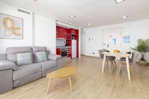 Una sala moderna con un sofá gris, una mesa de centro de madera y un comedor con mesa y sillas.