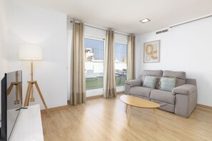 Un salon moderne avec un canapé, une table basse, une lampe et un tableau accroché au mur.