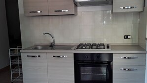 Una cocina moderna con electrodomésticos de acero inoxidable, horno empotrado y lavavajillas.