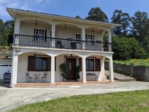 A two-story building with a balcony, a covered porch, and a garage. - COUNTRY HOUSE WITH EXCELLENT MOUNTAIN VIEWS (Cabanas (A Coruna))
