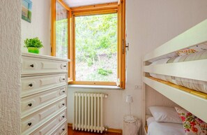 A bedroom with a window, a radiator, a dresser, and a bunk bed. - VillaSubasioRelax, panoramic villa with swimming pool, natural park, Spello, Assisi (Spello PG)