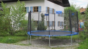 A house with a trampoline in front, surrounded by greenery. - Close to the mountains! (Pfronten)