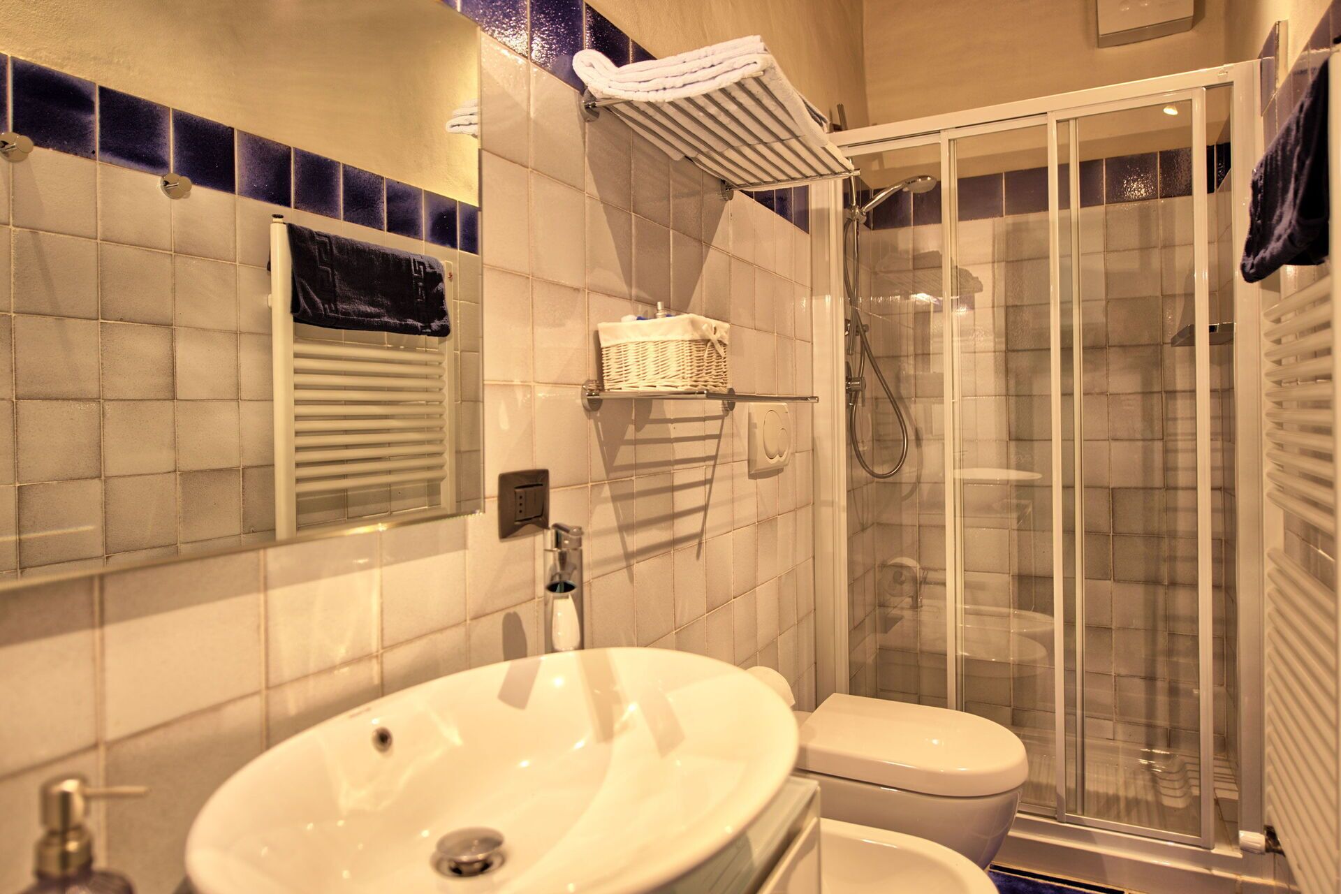 A bathroom with a sink, toilet, and glass-enclosed shower.