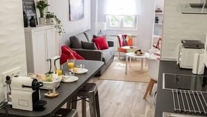 A modern kitchen with a dining area, bar stools, and a view of the living room. - VALTOUR New apartment Downtown+Wifi+A/C+Terrace (Valladolid)