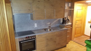 A kitchen with wooden cabinets, a stainless steel sink, a coffee maker, and a Siemens oven.