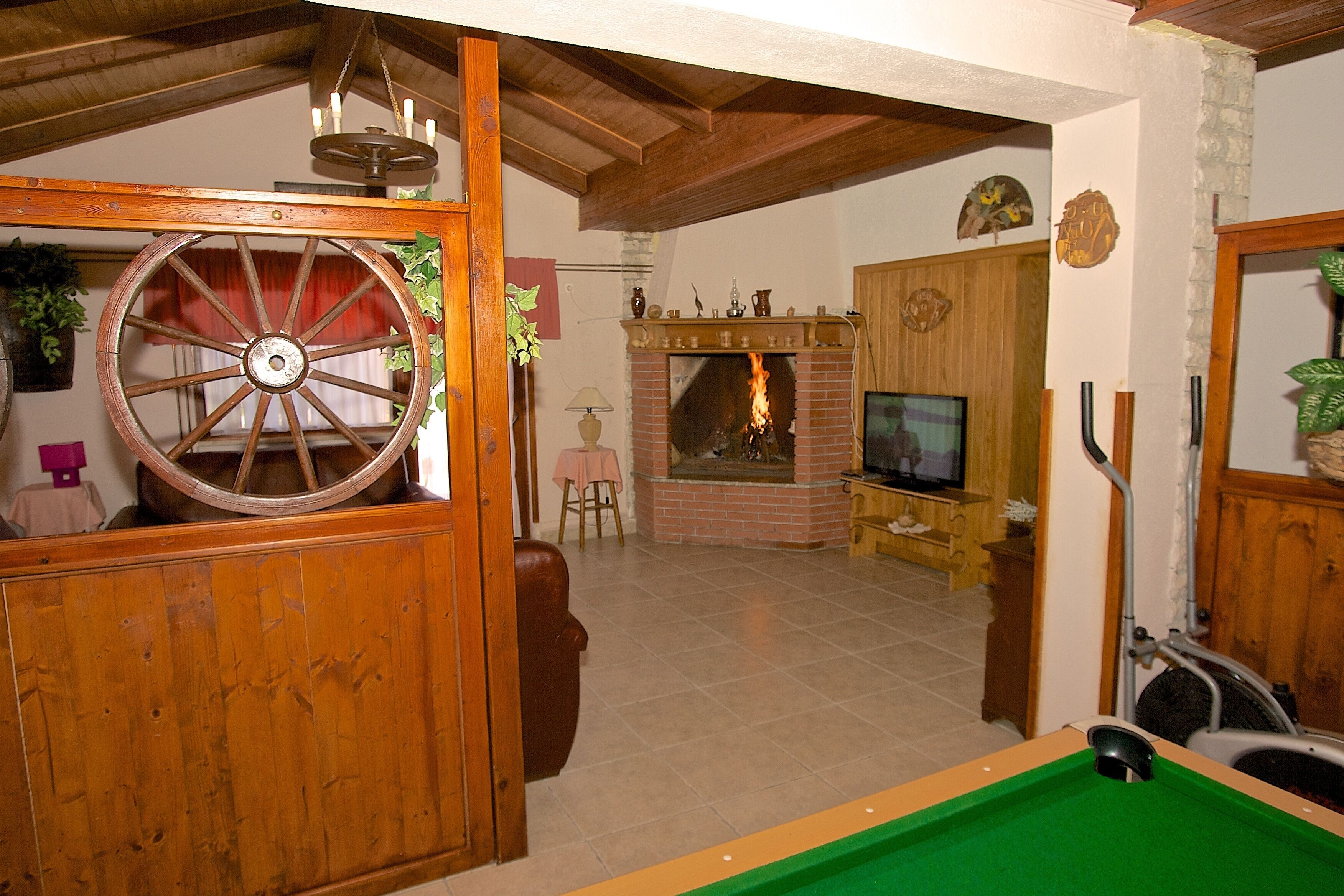 Ein gemütliches Wohnzimmer mit Kamin, Fernseher und Billardtisch.