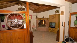 Una sala acogedora con chimenea de ladrillo, televisor y mesa de billar.