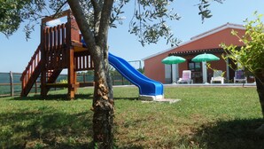Un parque infantil con un tobogán y una estructura de juego de madera.