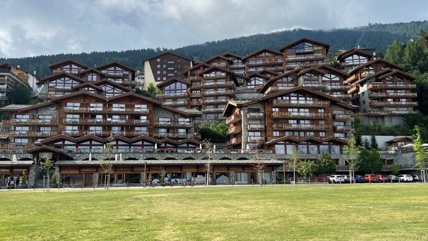 Ein großes Hotel mit mehreren hölzernen Balkonen und einem zentralen Gebäudebereich.