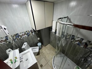 Habitación triple | Baño | Cabezal de ducha tipo lluvia y artículos de higiene personal gratuitos