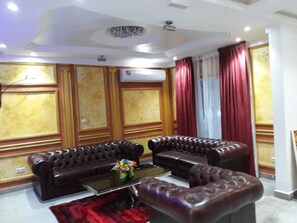 Relax in this elegantly designed living room with a comfortable sofa set, ornate paneling, and a stylish rug.