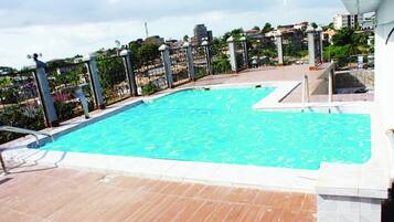 Una piscina al aire libre, tumbonas