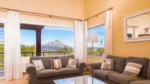 A living room with two sofas, a glass coffee table, and a view of a mountain. - LUXURY AIR-CONDITIONED VILLA WITH SEA VIEW 5 BED 10 PEOPLE WI FI (Jávea)