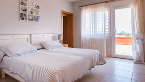 A bedroom with a bed, a bedside table, a lamp, a window with curtains, and a view of the outside. - LUXURY AIR-CONDITIONED VILLA WITH SEA VIEW 5 BED 10 PEOPLE WI FI (Jávea)