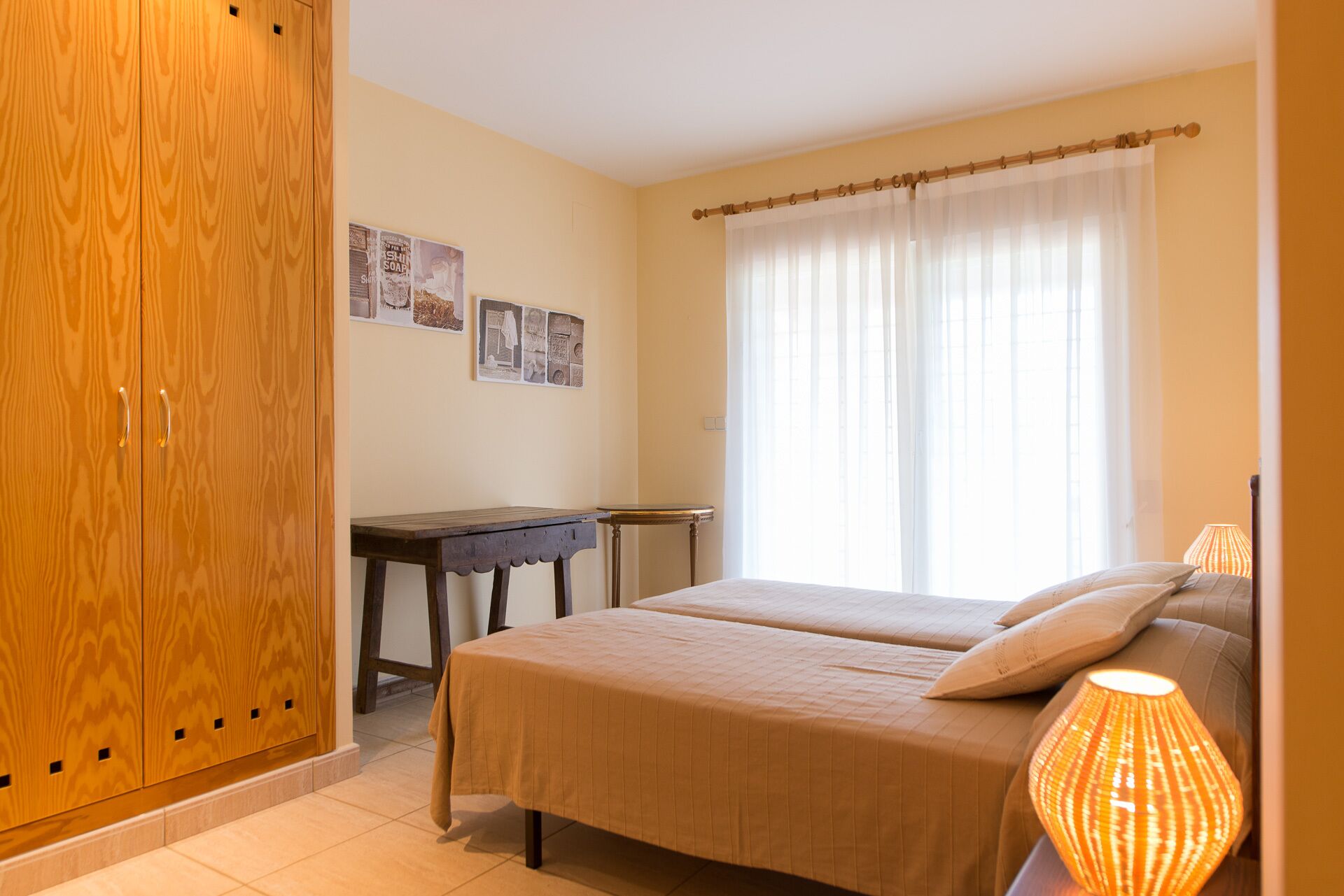 A bedroom with a bed, a desk, and a wardrobe.