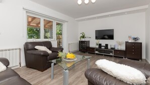 A modern living room with a glass coffee table, leather sofas, a TV, and a cabinet with electronic devices. - Beautiful home in Glavina Donja (Glavina Donja)