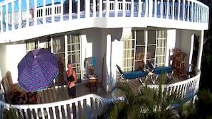 Une maison moderne dotée d’un balcon incurvé, de grandes fenêtres et d’un espace piscine.
