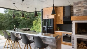 Una cocina moderna con una isla grande, taburetes de bar y un horno empotrado.