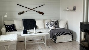 Una sala acogedora con un sofá blanco, una mesita de centro y una chimenea.