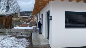 A modern building with a sloped roof and a person opening a door. - Warm magic in the heart of the Black Forest (Titisee-Neustadt)