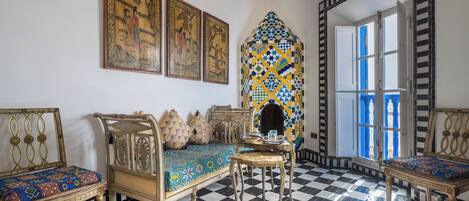 Una habitación con suelo de cuadros, muebles ornamentados y obras de arte tradicionales.