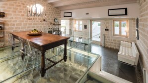 A spacious kitchen with a wooden table, clear chairs, and a bowl of fruit. - Villa with pool and private wellness area in Scicli, Sicily - 8 pax (Scicli)