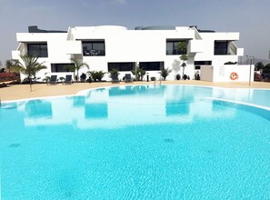 Un bâtiment moderne avec une piscine devant.
