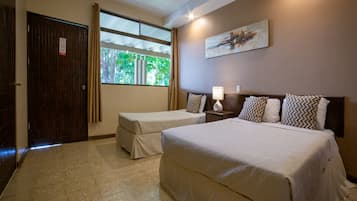 Habitación de hotel con una cama grande, una cama más pequeña, una ventana con cortinas, un cuadro en la pared y un ventilador de techo.