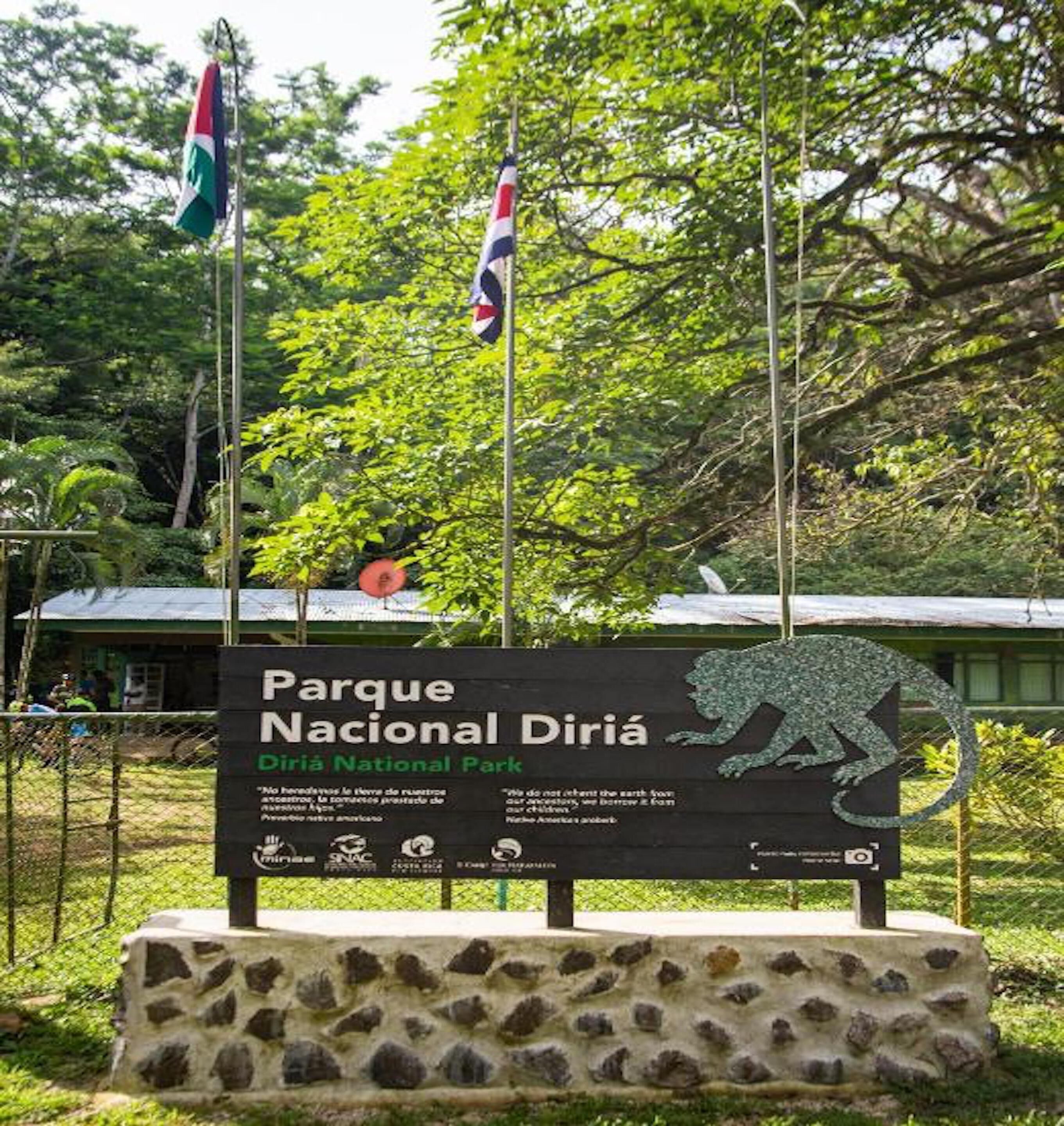 Ein Schild für den Nationalpark Diria mit Steinsockel und einer Jaguar-Skulptur.