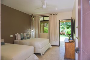 A hotel room with two beds, a ceiling fan, a TV, and a view of the garden. - Hotel Diriá Santa Cruz (Santa Cruz)
