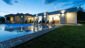 A modern house with a swimming pool, outdoor seating, and a well-lit patio area. - Lovely home in Dicmo with sauna (Dicmo)