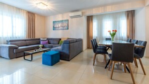 A modern living room with a sectional sofa, a coffee table, and a dining area with a table and chairs. - Lovely home in Dicmo with sauna (Dicmo)