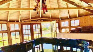 Una amplia piscina interior con techo de madera y varias ventanas.